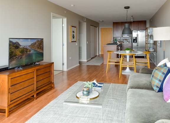 a living room and dining room with a couch and a tv at Optima Old Orchard Woods, Skokie, Illinois