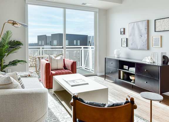 a living room with furniture and a large window at The Hallon Apartments, Minnesota, 55343