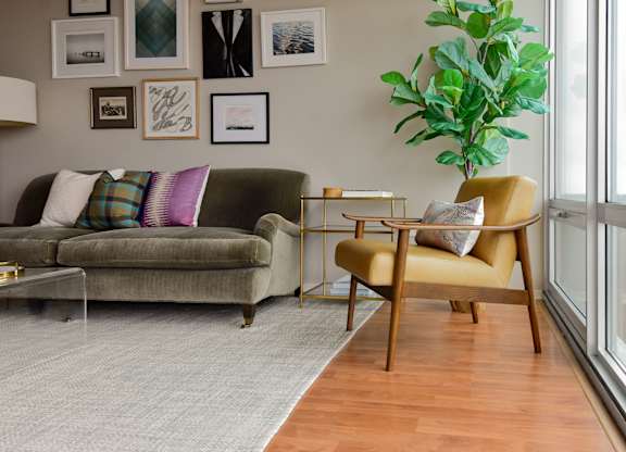 a living room with a couch and a chair and a plant at Optima Old Orchard Woods, Skokie, 60077