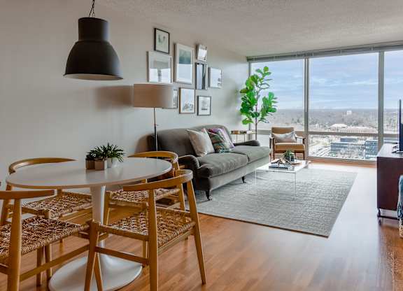 a living room with a view of the city and a table and chairs at Optima Old Orchard Woods, Illinois, 60077