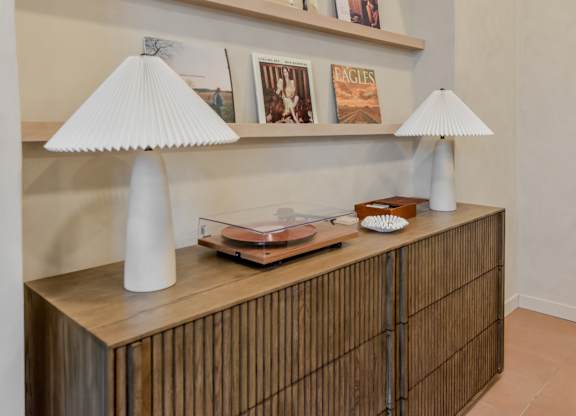 A wooden cabinet with a lamp and a book on top.