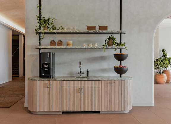 A modern kitchen with a wooden counter and a black fridge.