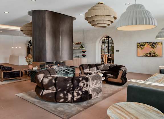 A modern living room with a large circular column and a variety of seating options.