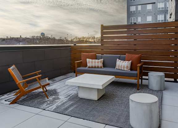 A wooden chair and a white table are on a patio.