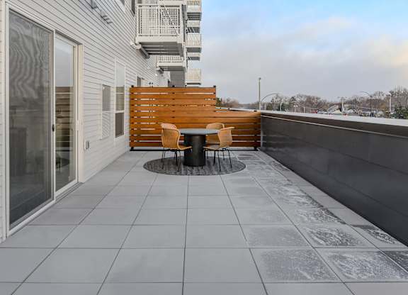 A patio with a table and chairs on a balcony.