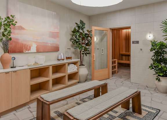 A room with a wooden bench and a painting on the wall.