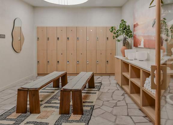 A room with wooden benches and lockers.