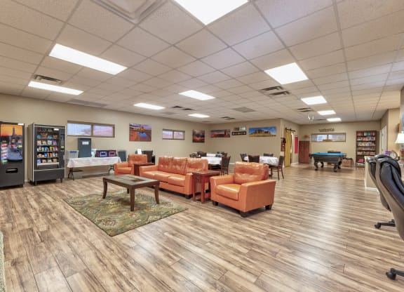 a common room with couches and chairs and a pool table