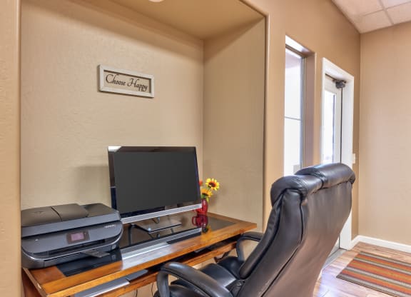 a home office with a desk with a computer and a chair