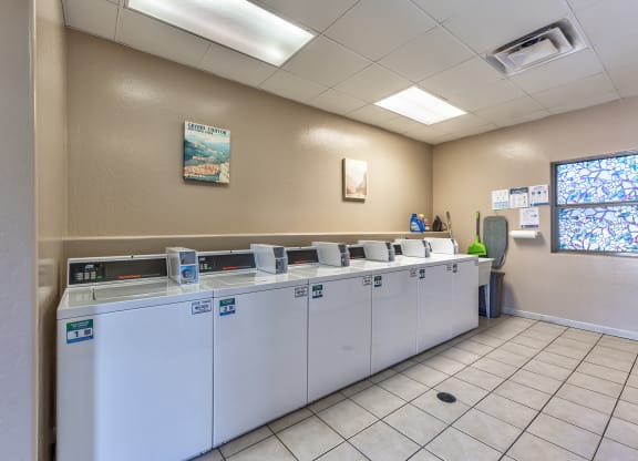 a row of washers and dryers in a laundry room