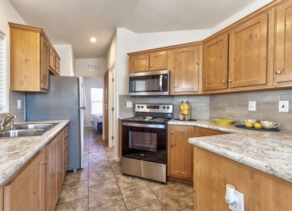 a kitchen with wooden cabinets and stainless steel appliances and granite counter tops