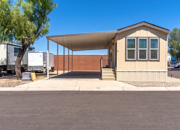 a small tan building with a porch and a truck parked in front