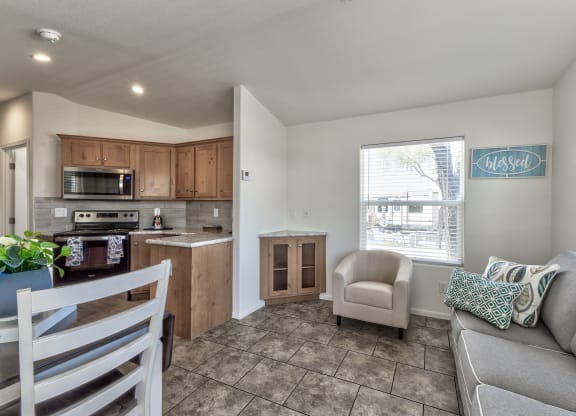 a living room with a couch and a chair and a kitchen