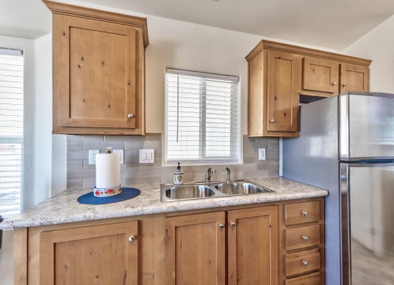 a kitchen with wooden cabinets and a stainless steel refrigerator