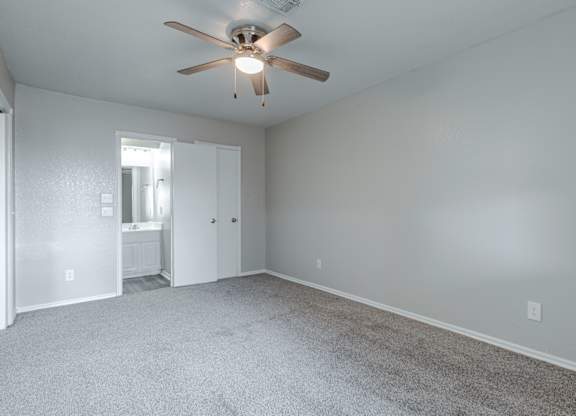 A room with a ceiling fan and carpeted floor.