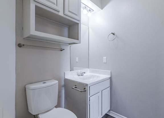A white toilet and sink in a small bathroom.