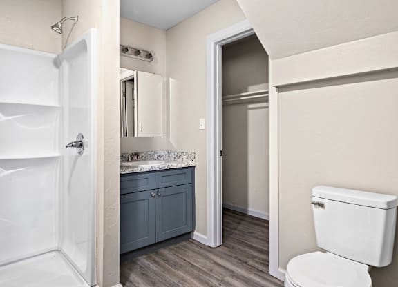 A white toilet sits next to a white bathtub in a bathroom.