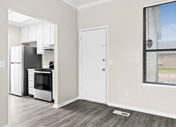A kitchen with a white fridge and stove with a white door.