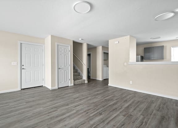 A spacious room with wooden floors and white walls.