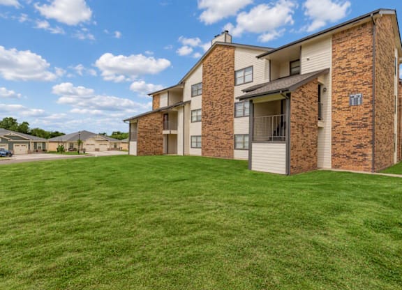 A large grassy area in front of apartment buildings.