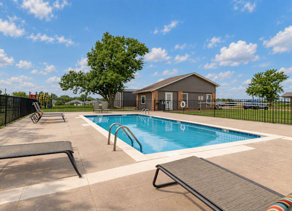 A pool with a slide and a house in the background.