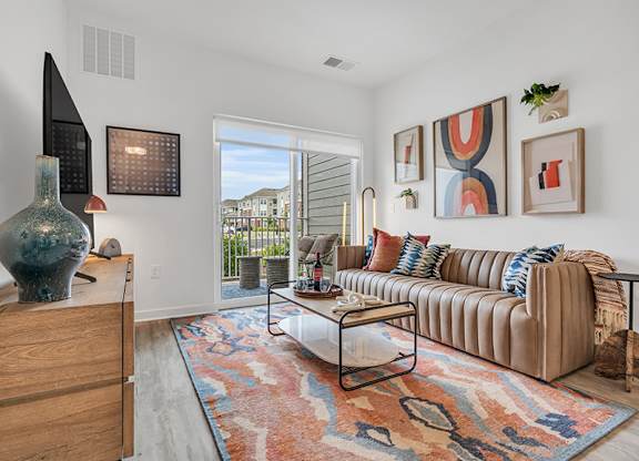 A living room with a couch, a table, and a vase.