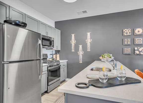 A modern kitchen with a stainless steel refrigerator and a white countertop.