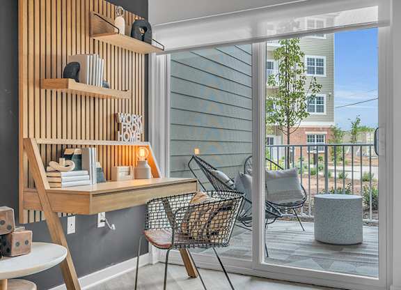 A room with a desk, chair, and a shelf with a sign that says