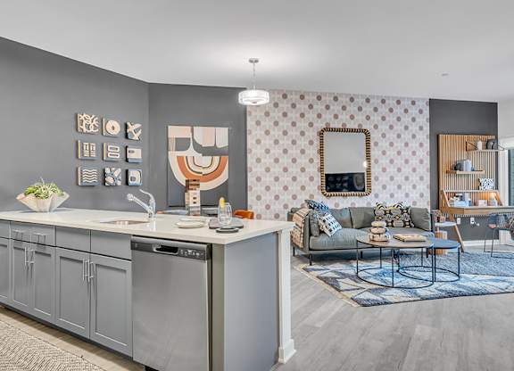 A modern kitchen with a grey cabinetry and a grey and white patterned wallpaper.