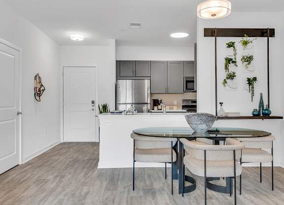 A modern kitchen with a dining table and chairs.