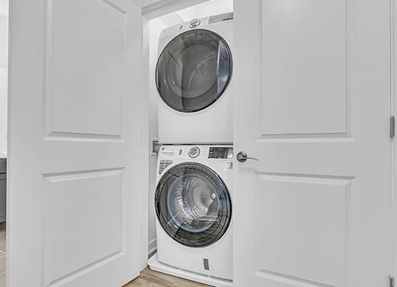A white washing machine is in a white door.