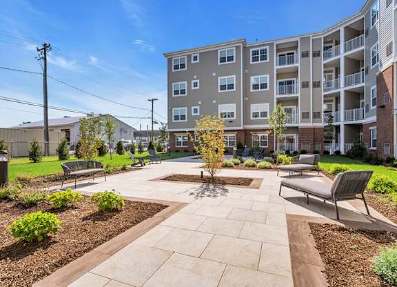 A sunny day at a residential complex with a courtyard and benches.