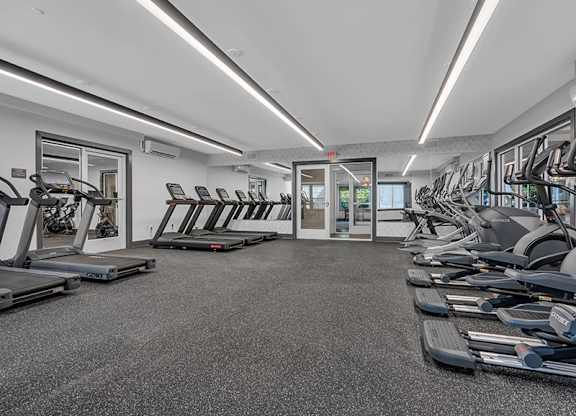 A gym with treadmills and elliptical machines.