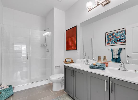 A bathroom with a toilet, sink, and shower.