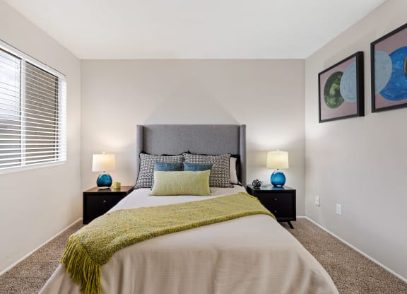 Bedroom with Bed and end tables with lamps at Verde Apartments in Tucson, AZ!