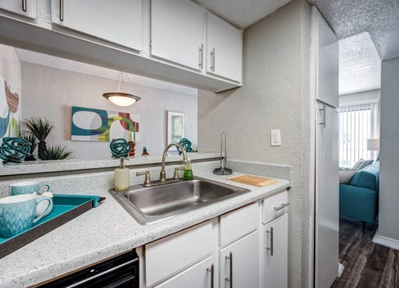 a kitchen with white cabinets and a sink at Sundance and Sausalito Apartments, College Station, Texas