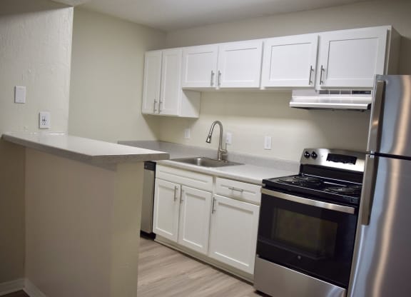 a kitchen with stainless steel appliances and white cabinets