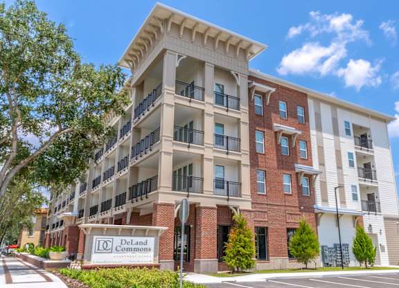 A multi-story apartment building named DeLand Commons is shown.