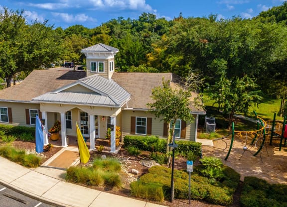 an aerial view of a house with a playground and trees