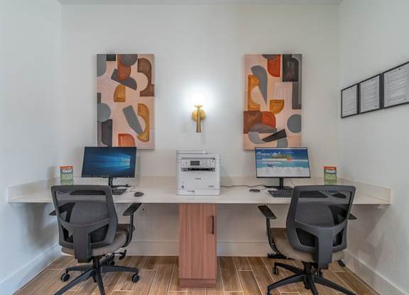 A modern office with two computers and two chairs.