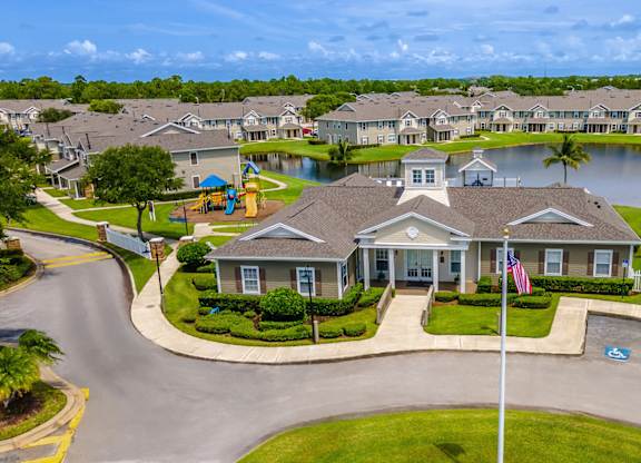 A residential area with a house in the foreground and a playground in the background.