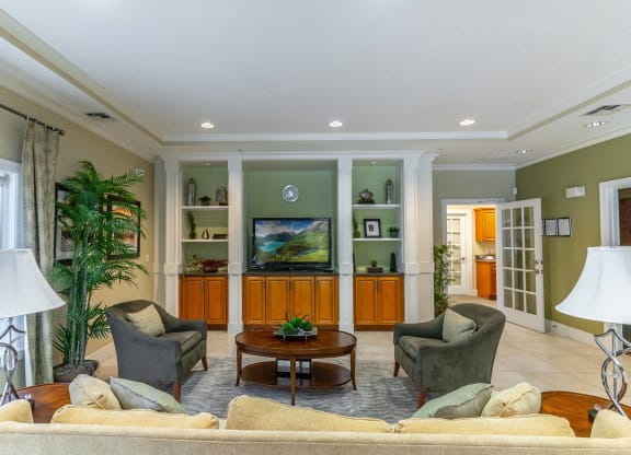 a living room with a couch and chairs and a tv
