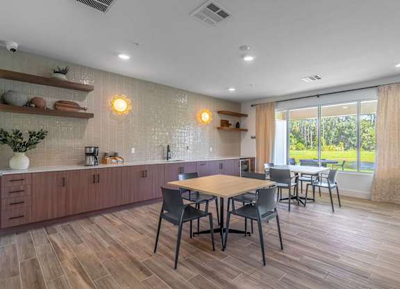 A kitchen with a table and chairs in front of a window.