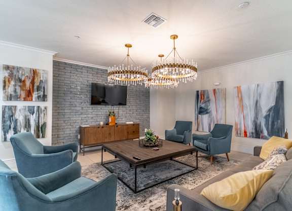 A living room with a grey couch, a wooden coffee table, and a chandelier.
