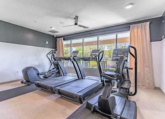 A spacious gym with treadmills and elliptical machines.