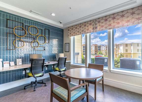 A room with a table and chairs and a window with a view of buildings outside.