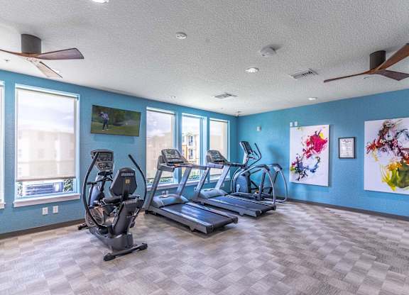 A spacious gym with treadmills and elliptical machines.