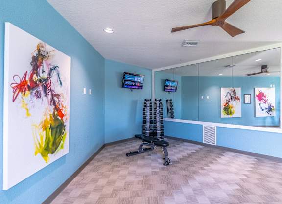 A room with a blue wall and a painting on it.