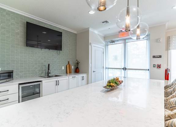 A modern kitchen with a white countertop and a microwave oven.