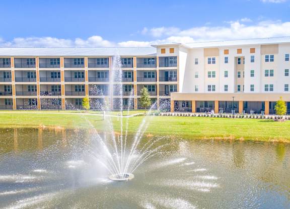 A fountain in the foreground of a building.